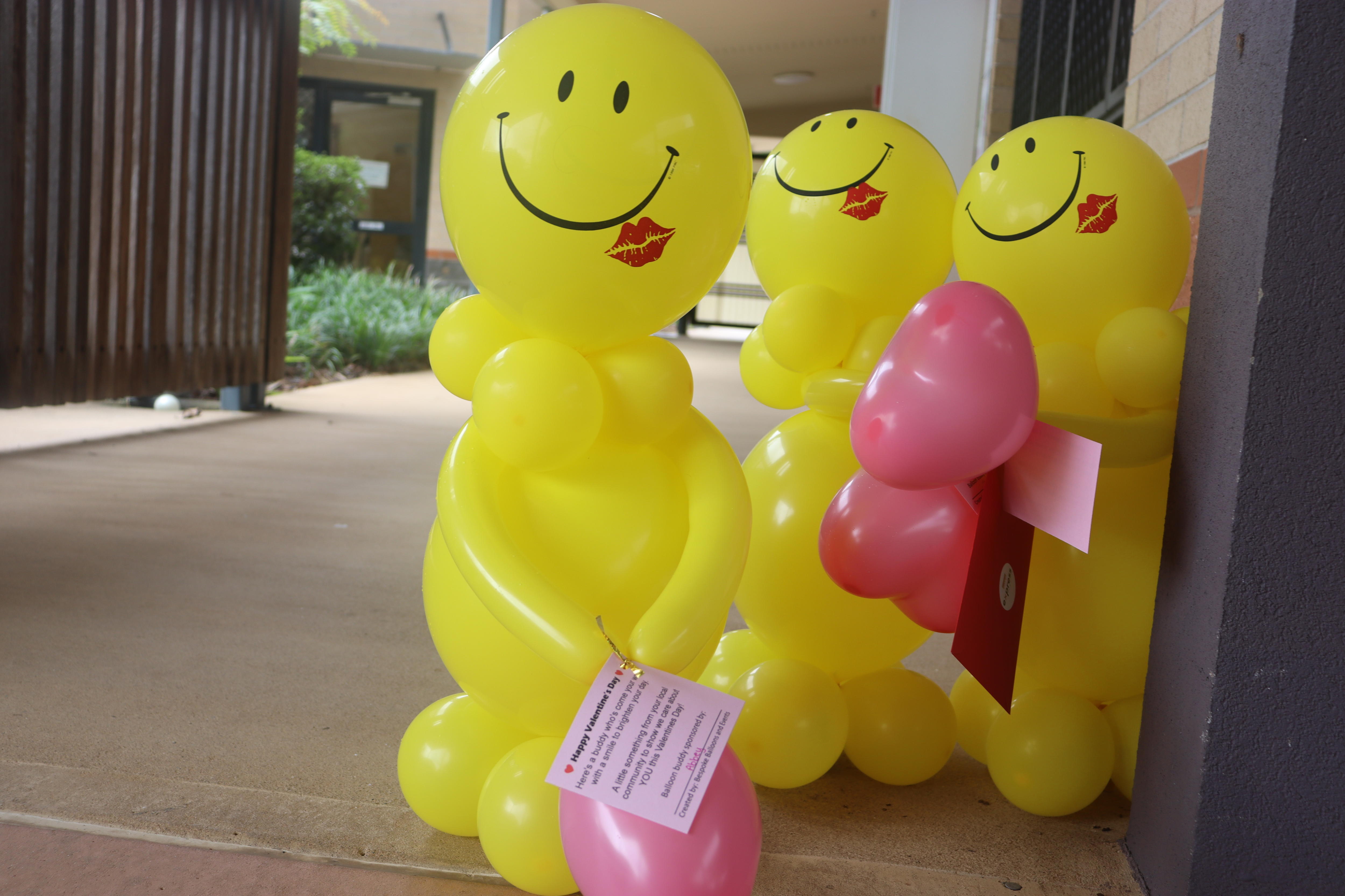 Large yellow balloons with smiley faces shaped into people 