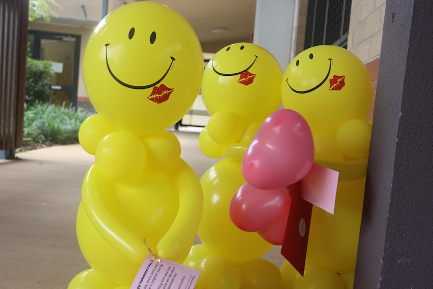 Large yellow balloons with smiley faces shaped into people 