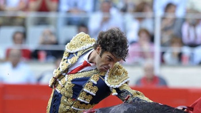 Spanish bullfighter Jose Tomas performing a pass on a bull