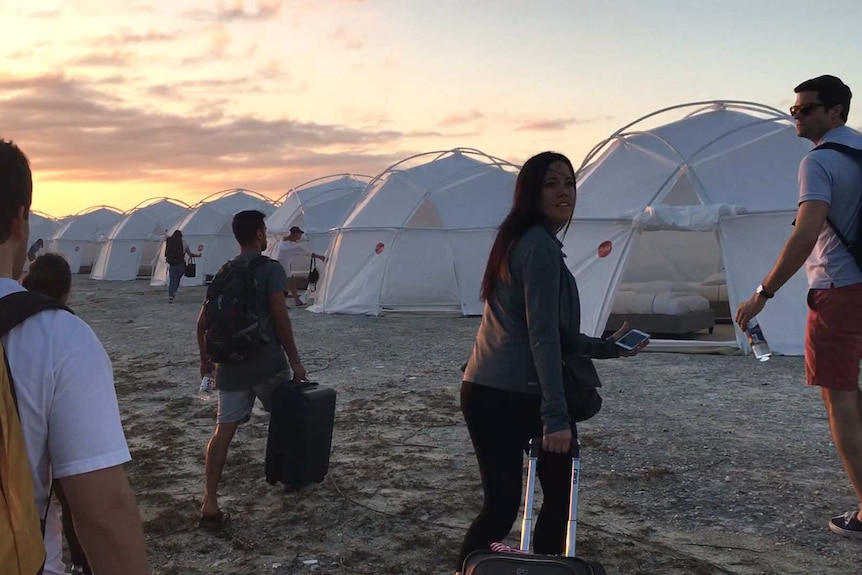Fyre Festival attendees walk towards their tents.