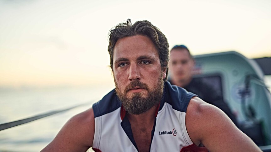 A close up on a man's face and shoulder in a row boat