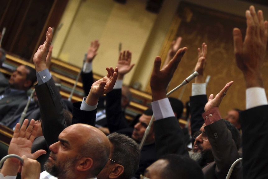 Members of the Muslim Brotherhood in the Shura Council raise their hands to approve judicial reforms.