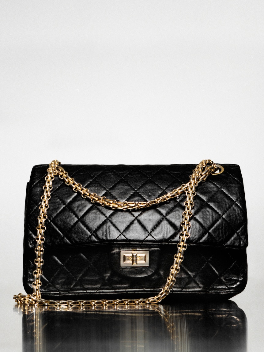 A black quilted leather handbag with a gold chain and clasp