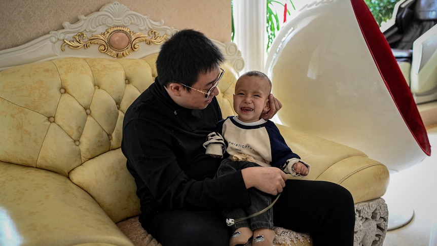  Xu Haoyang  diagnosed with Menkes syndrome, smiling as his father Xu Wei plays with him at home in Kunming