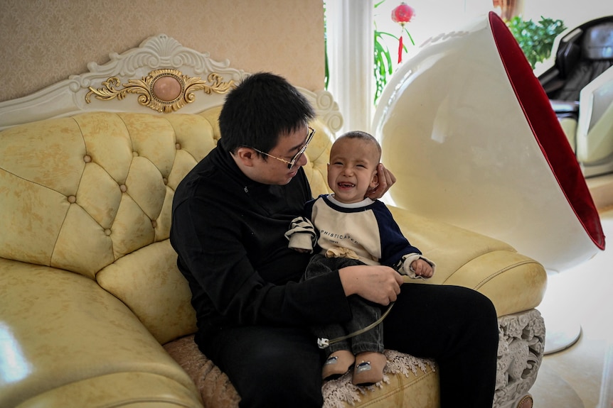  Xu Haoyang  diagnosed with Menkes syndrome, smiling as his father Xu Wei plays with him at home in Kunming