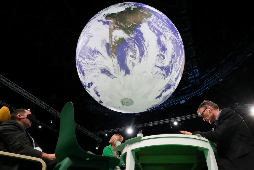 Delegates rest under a giant inflatable globe at a convention centre.