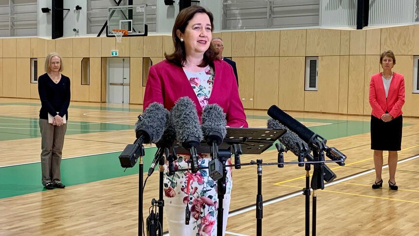 Queensland Premier Annastacia Palaszczuk stands in front of microphones