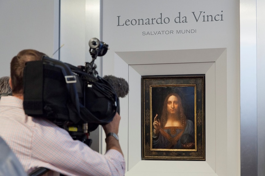 A cameraman films Leonardo da Vinci's painting Salvator Mundi.