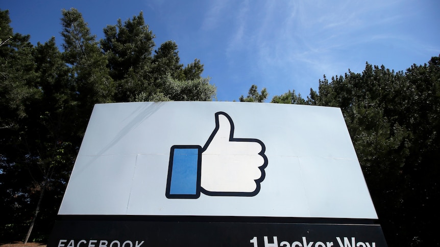 Thumbs up Facebook logo on a big sign with forest behind 