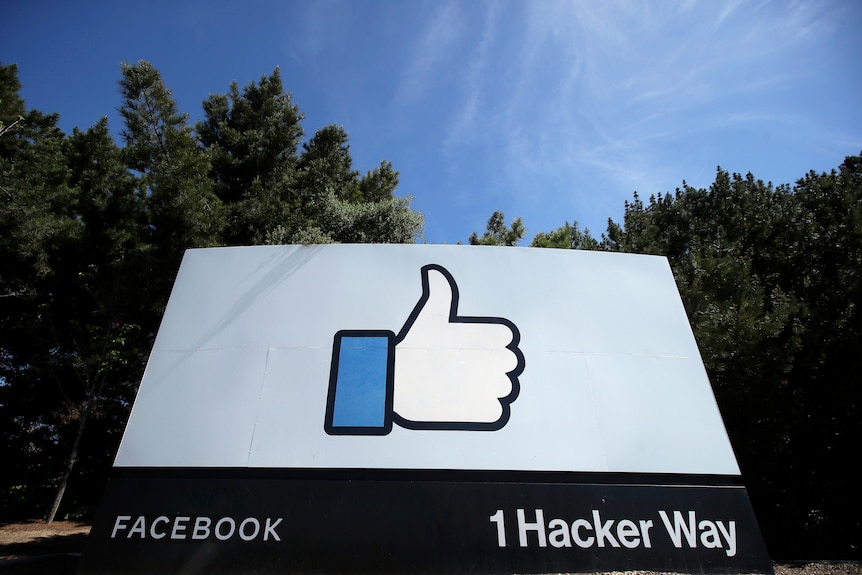 Thumbs up Facebook logo on a big sign with forest behind 