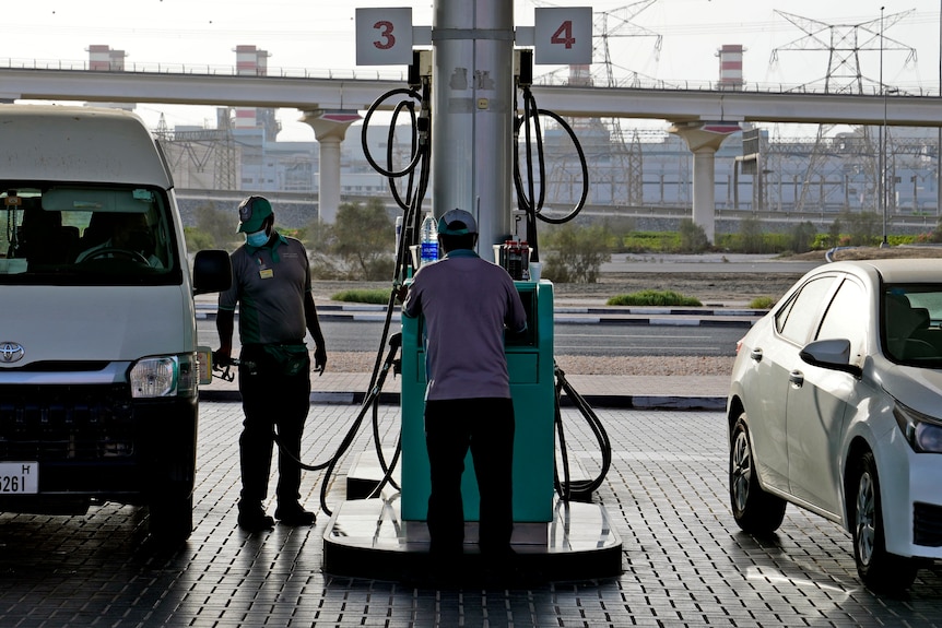 A man fills up a car at a petrol station