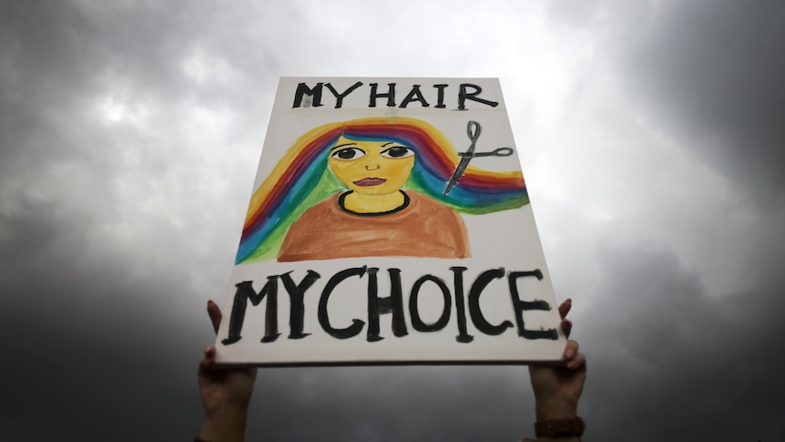 A woman holds a placard saying "My hair my choice" during a protest against the death of Iranian Mahsa Amini, in Berlin.