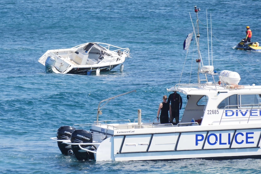 A small runabout boat in Botany Bay and a police boat and jetski watching it being towed.