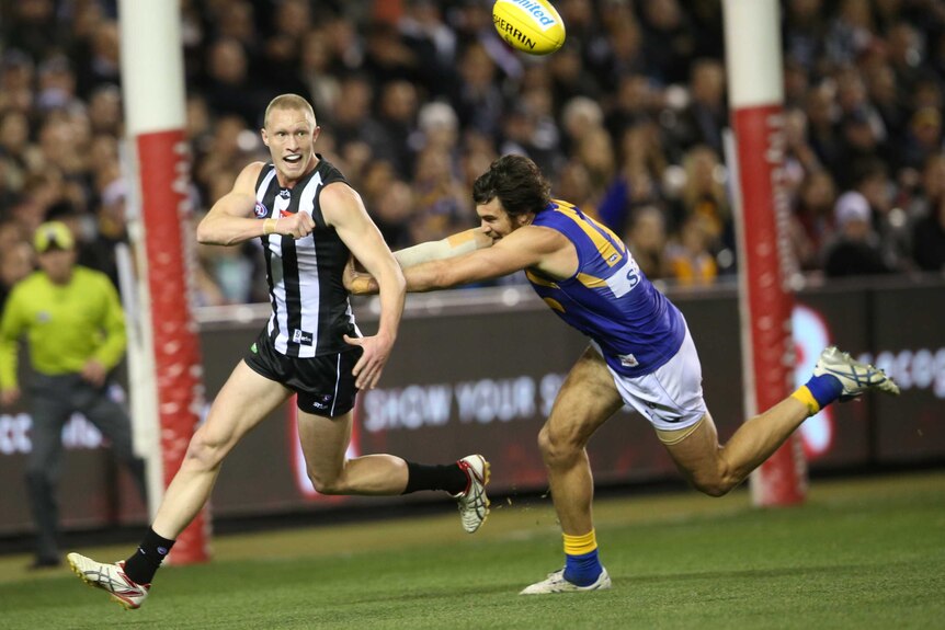 A Magpies player and a West Coast Eagles player during an AFL match.