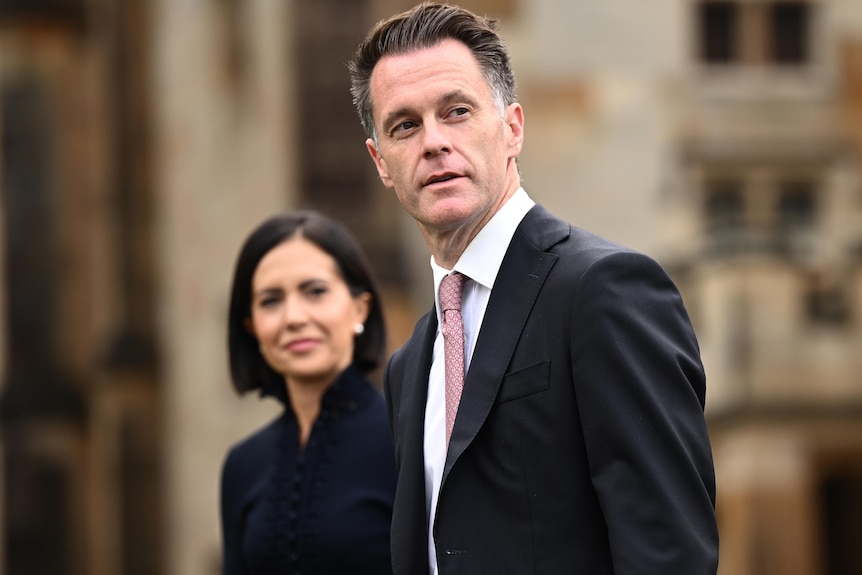 A man and woman dressed in black suits