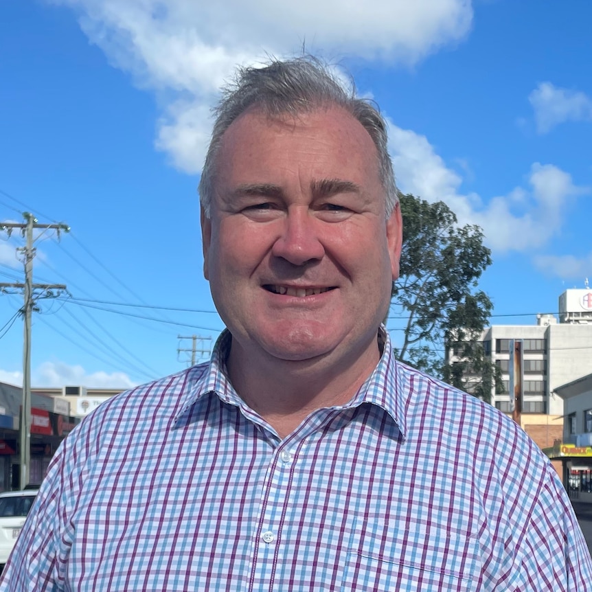 Man stands in the middle of a CBD smiling 