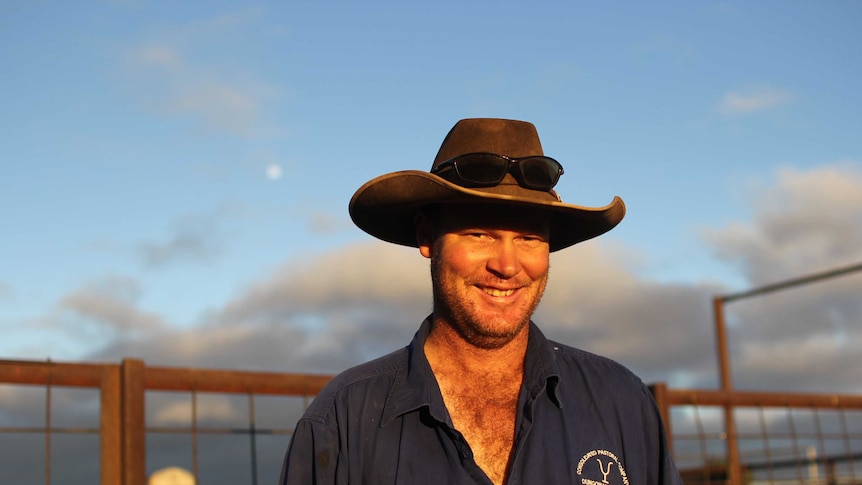 a man standing in front of cattle yards