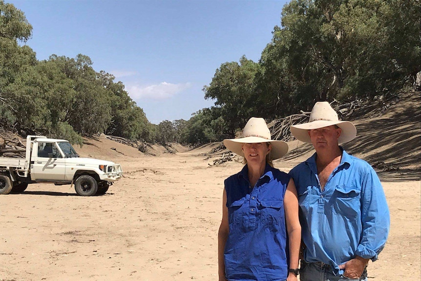 Bill and Chrissie Ashby stand in the dry and brown riverbed.