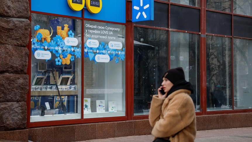 A woman walks past a store of Ukraine's telecommunications company Kyivstar.