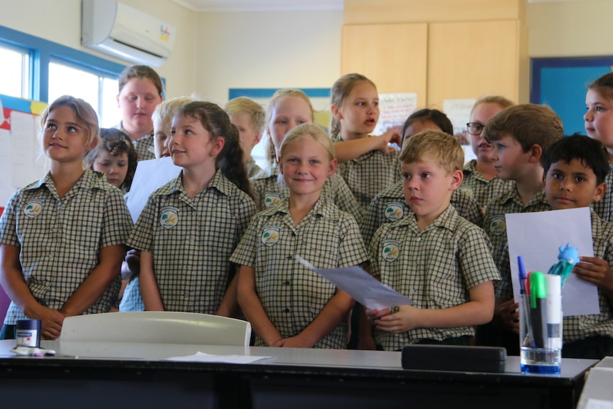 School students prepare to sing a song in a classroom.