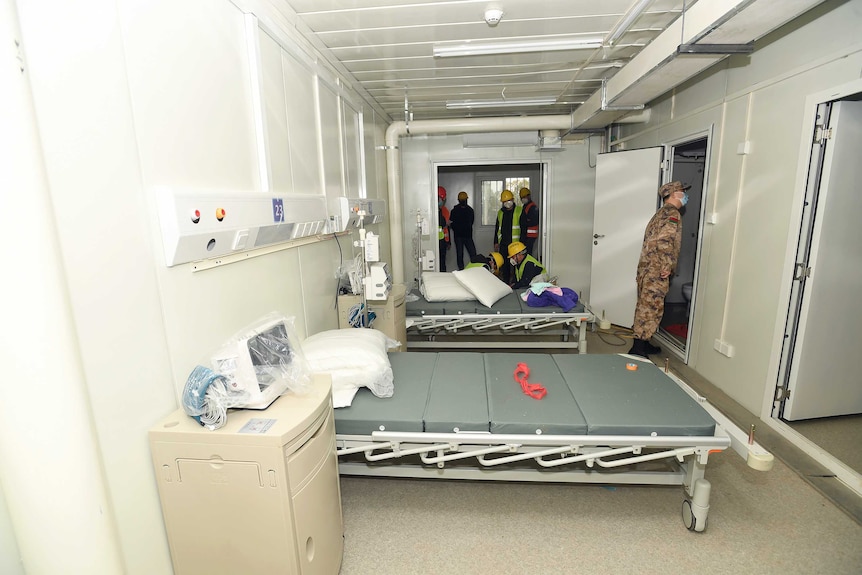 A Chinese medic looks at a patient room at the temporary hospital in Wuhan.
