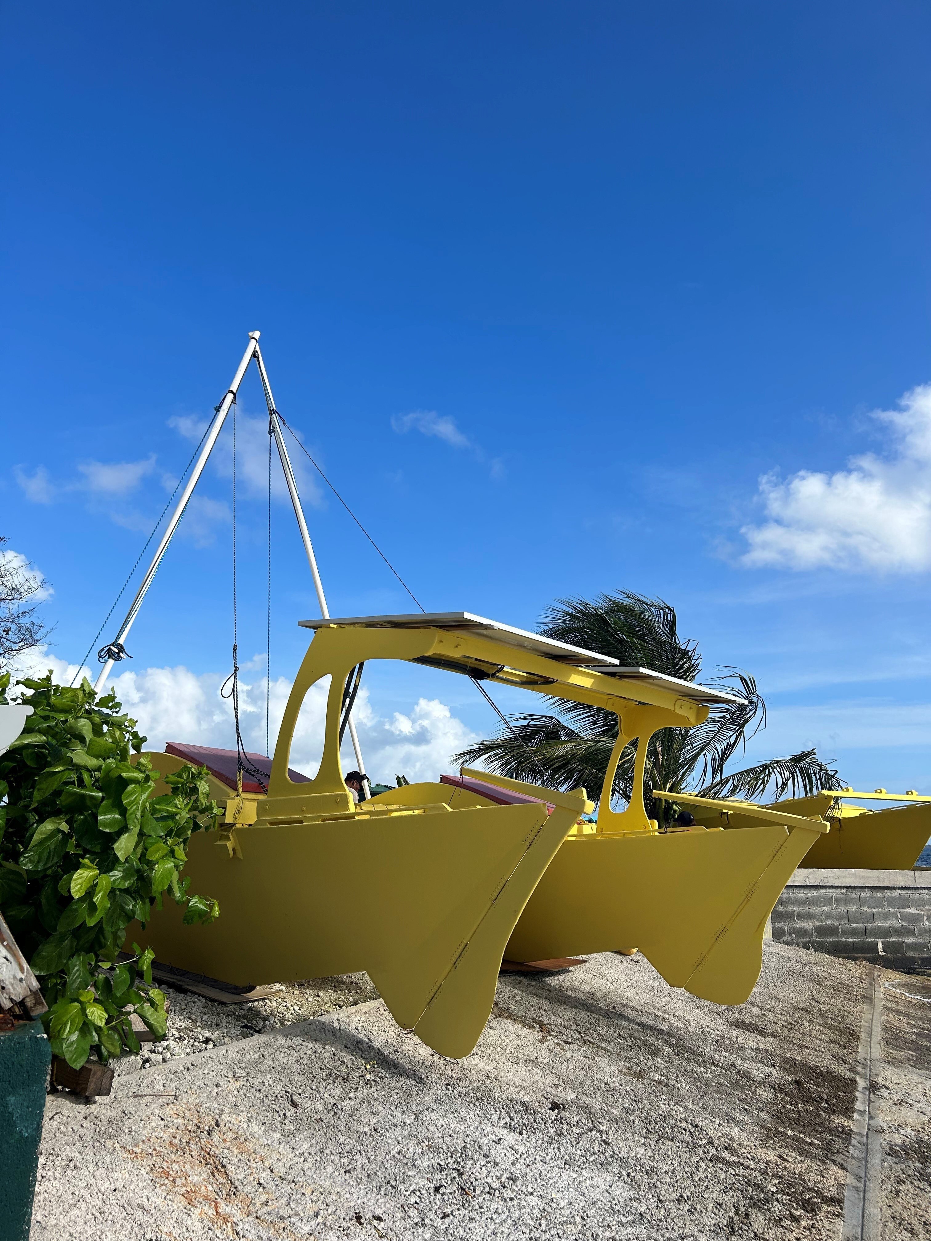 A bright yellow catamaran with solar panels