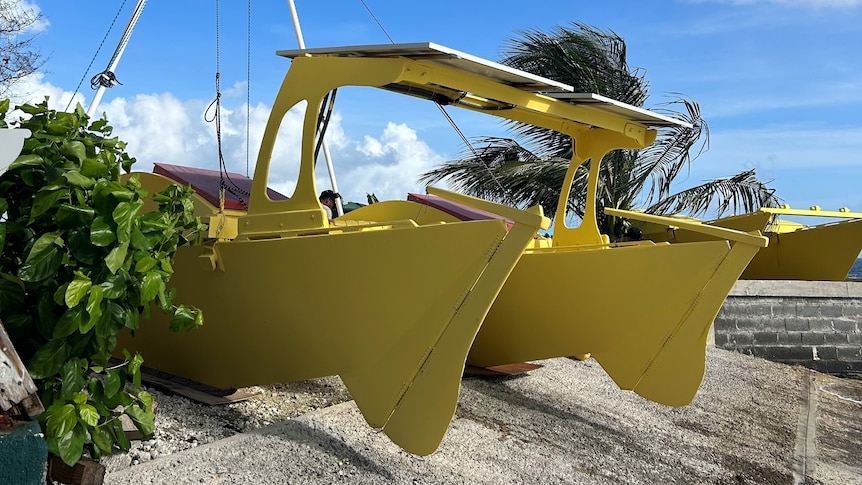 A bright yellow catamaran with solar panels