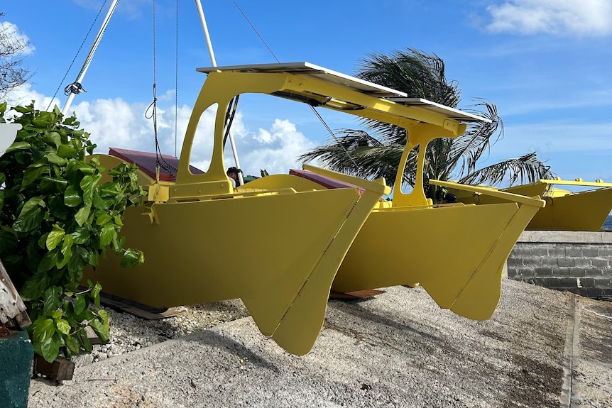 A bright yellow catamaran with solar panels