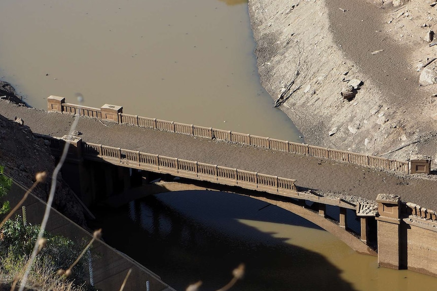 A bridge above water with sludge on it.