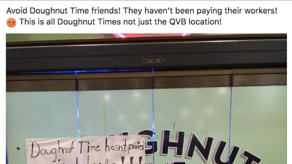 A paper sign stuck on a Doughnut Time store front says "Doughnut Time hasn't paid us in weeks and now we all got fired.