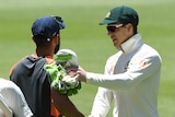 Australia cricket captain Tim Paine and India cricket captain Virat Kohli shake hands on the field after a Test match.