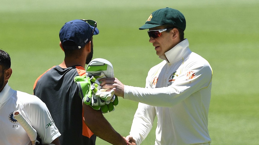 Australia cricket captain Tim Paine and India cricket captain Virat Kohli shake hands on the field after a Test match.