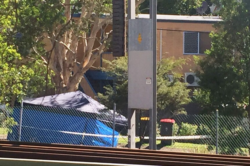 Police tent and police tape at scene of where a man wais killed in an attack outside his Kuraby home