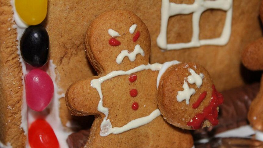 Gingerbread man holding a gingerbread head.