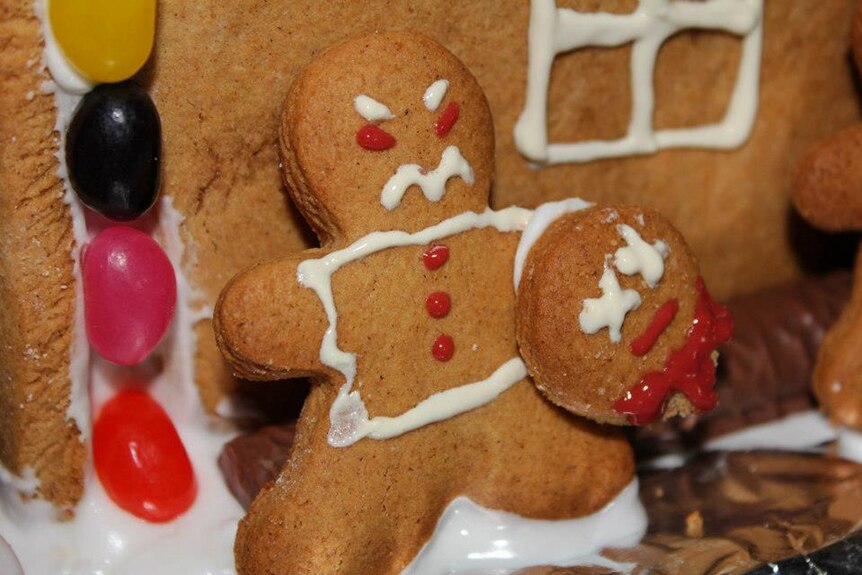 Gingerbread man holding a gingerbread head.
