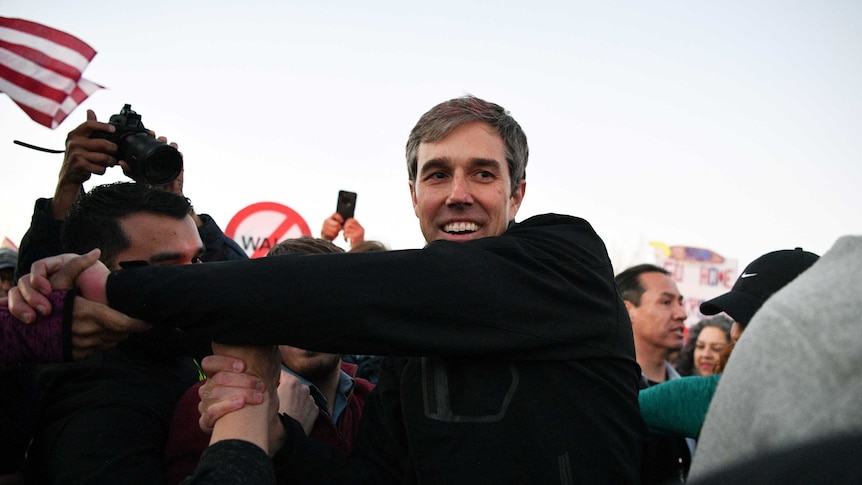 Beto O'Rourke shakes hands in a crowd of people.
