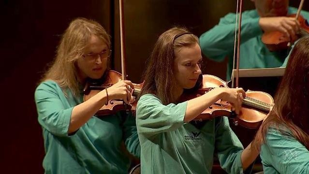 Female musicians play violin in orchestra