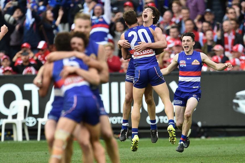 A group of Western Bulldogs players celebrate winning the grand final after the final siren.