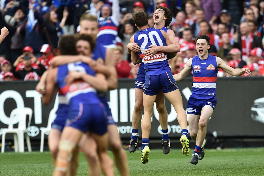 Western Bulldogs hug as they celebrate their AFL premiership victory