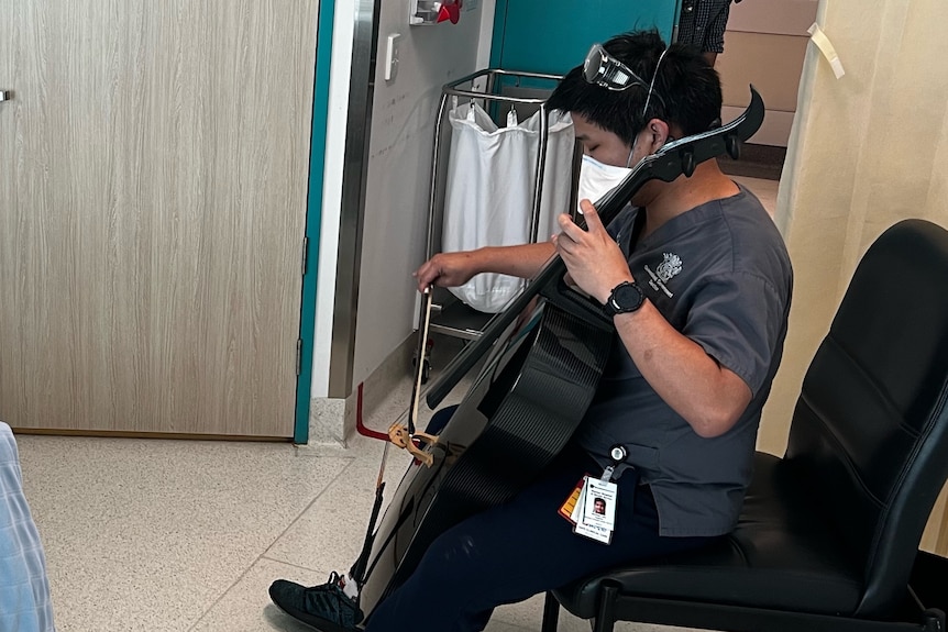 Dr Michael Lam plays cello to patient.