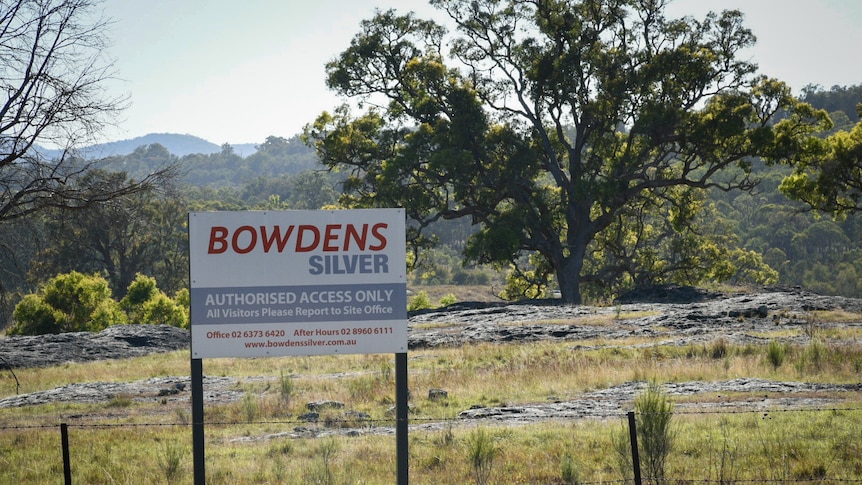 A sign reads Bowdens Silver in front of a grassy and rocky landscape with a tree