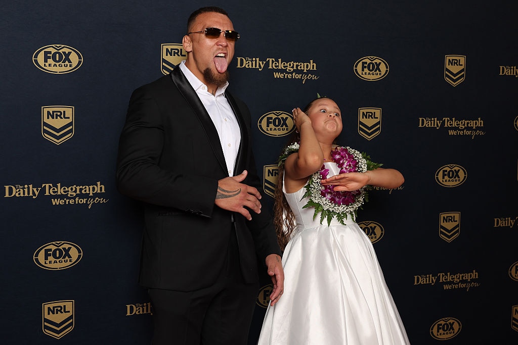 a man in a suit and shades poses next to his young daughter, both making fierce faces