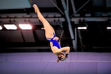 Melissa Wu upside down as she dives, holding her head and her stomach