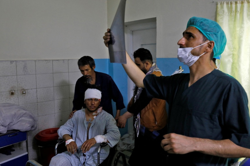 A medic checks an X-ray of a man who was wounded after a suicide bomber detonated explosives near the entrance of the Russian embassy in Kabul on September 5, 2022.