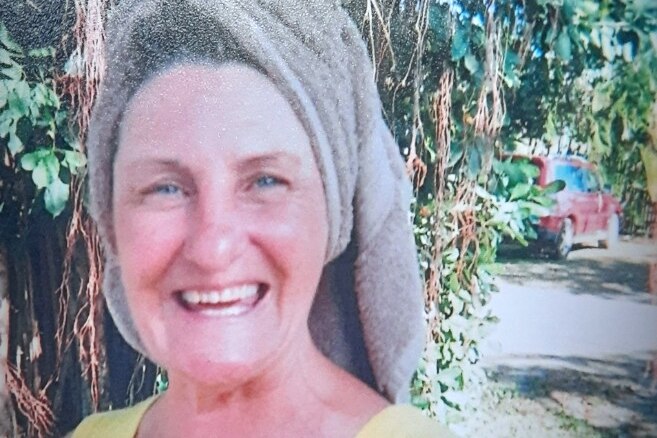 Close up photo of a smiling woman with a towel on her head
