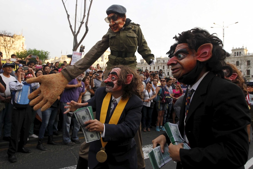 Protesters representing corruption, wearing masks and holding fake money.