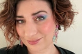 A selfie of Lauren Beckman with pink and blue eyeshadow and short curly hair
