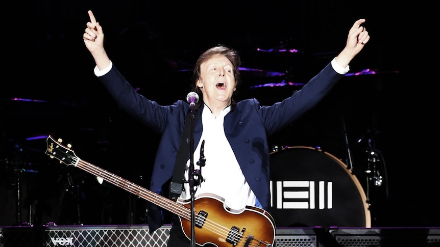 Paul McCartney sings with a guitar onstage in Seoul
