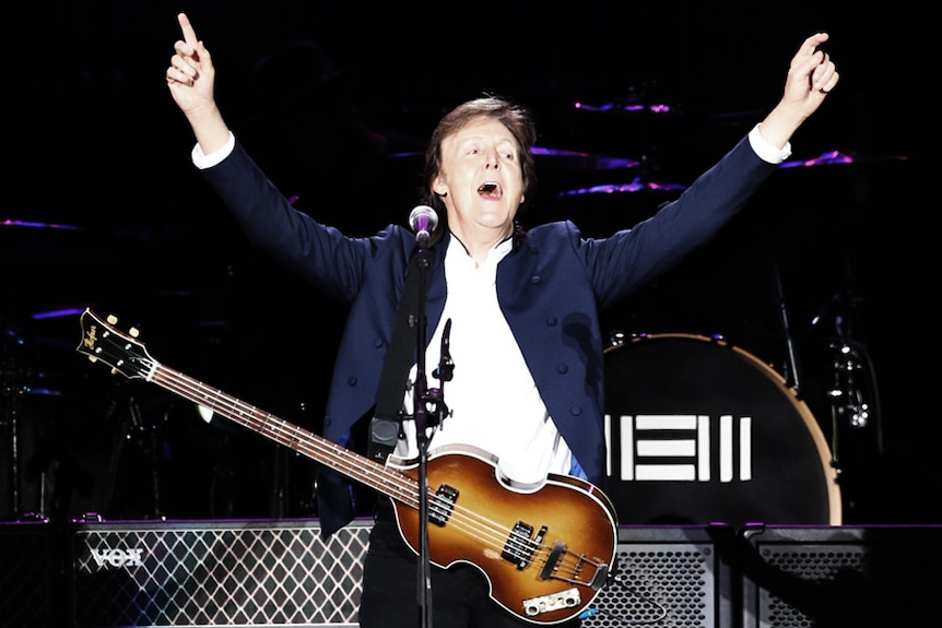 Paul McCartney sings with a guitar onstage in Seoul