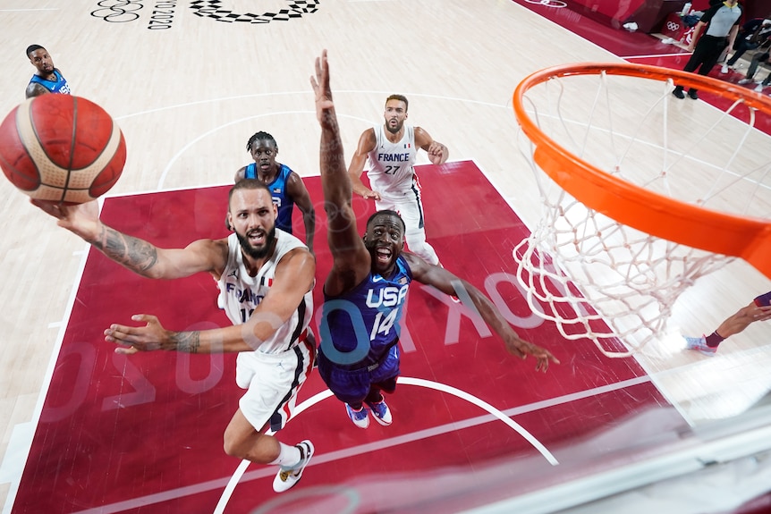 Evan Fournier shoots a layup over Draymond Green.